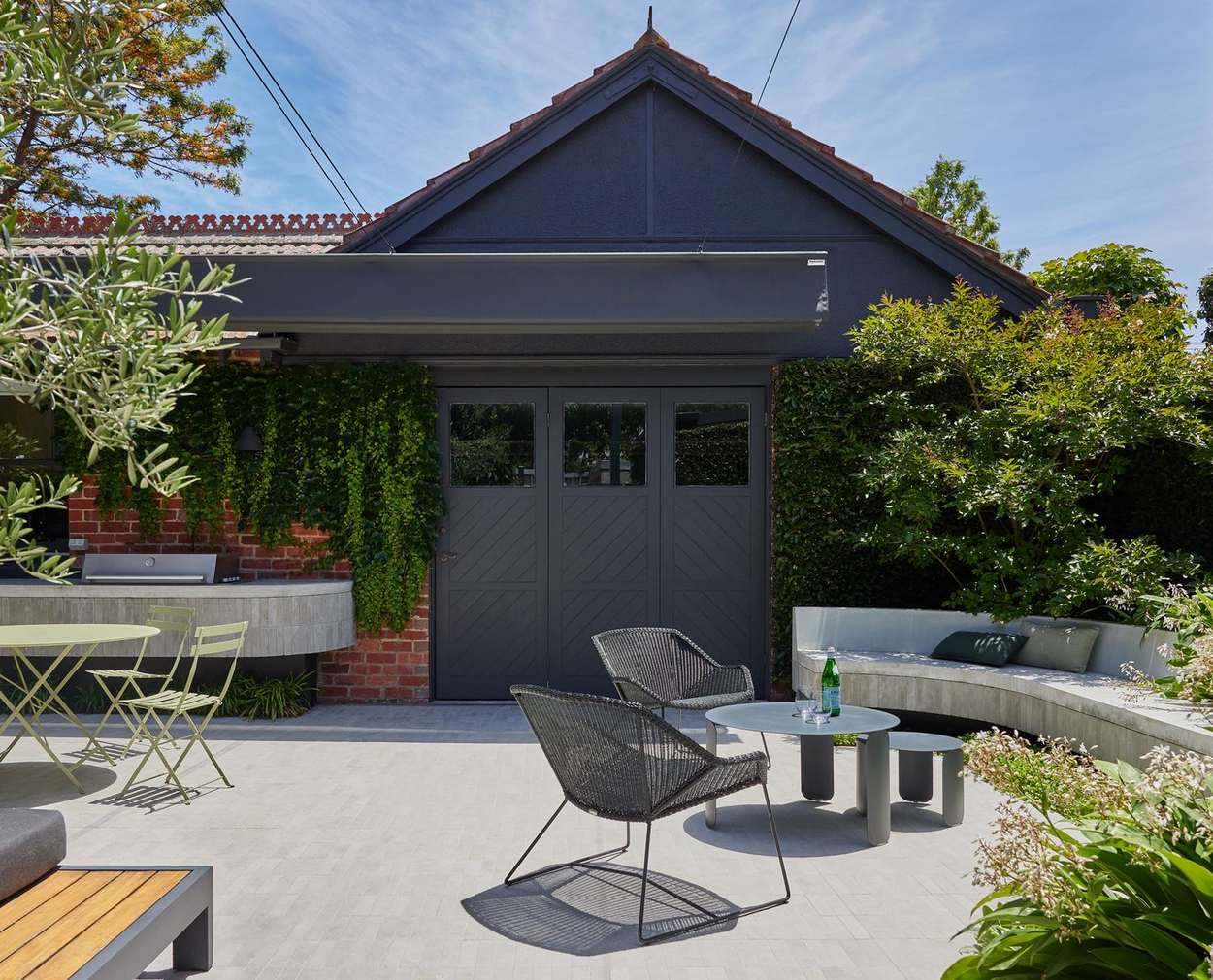 The courtyard looking toward the dark garage doors, hedged on three sides