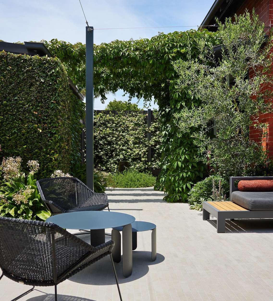 Woven lounge chairs and low tables on the paved courtyard