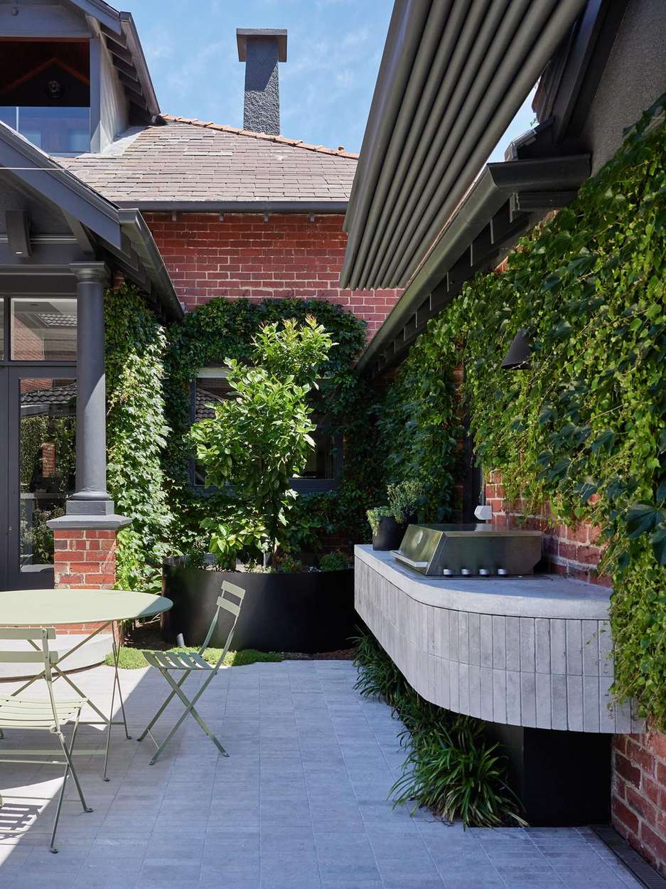 Outdoor kitchen and grill under the ivy-covered brick wall