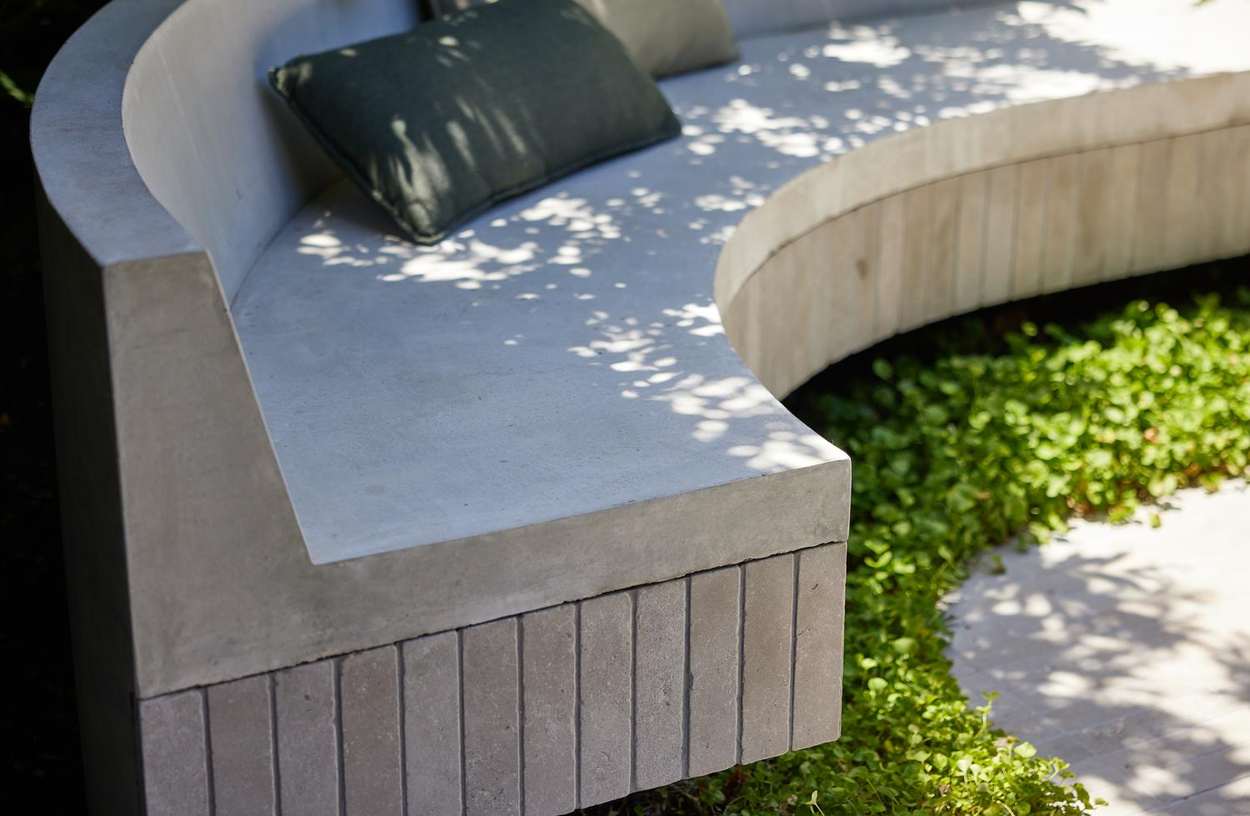 Close detail of the curved concrete bench seat and its brick soldier course