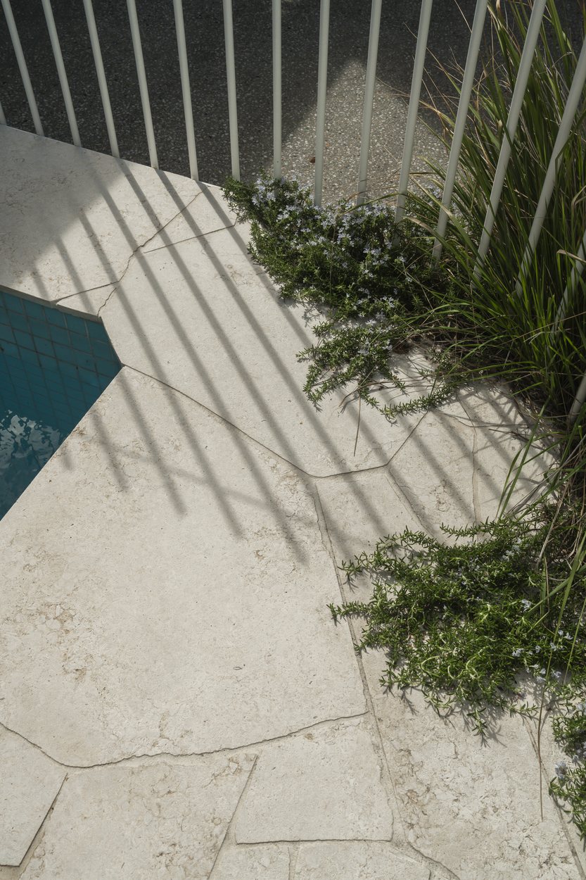 Limestone coping at the pool edge with coastal rosemary spilling over the paving