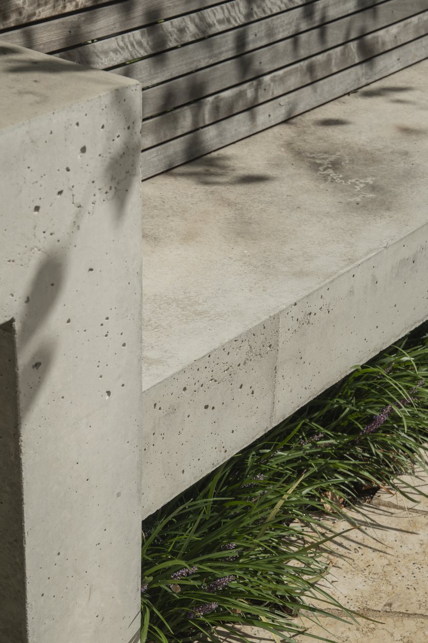 Detail of the board-formed concrete seat with its timber back, liriope beneath