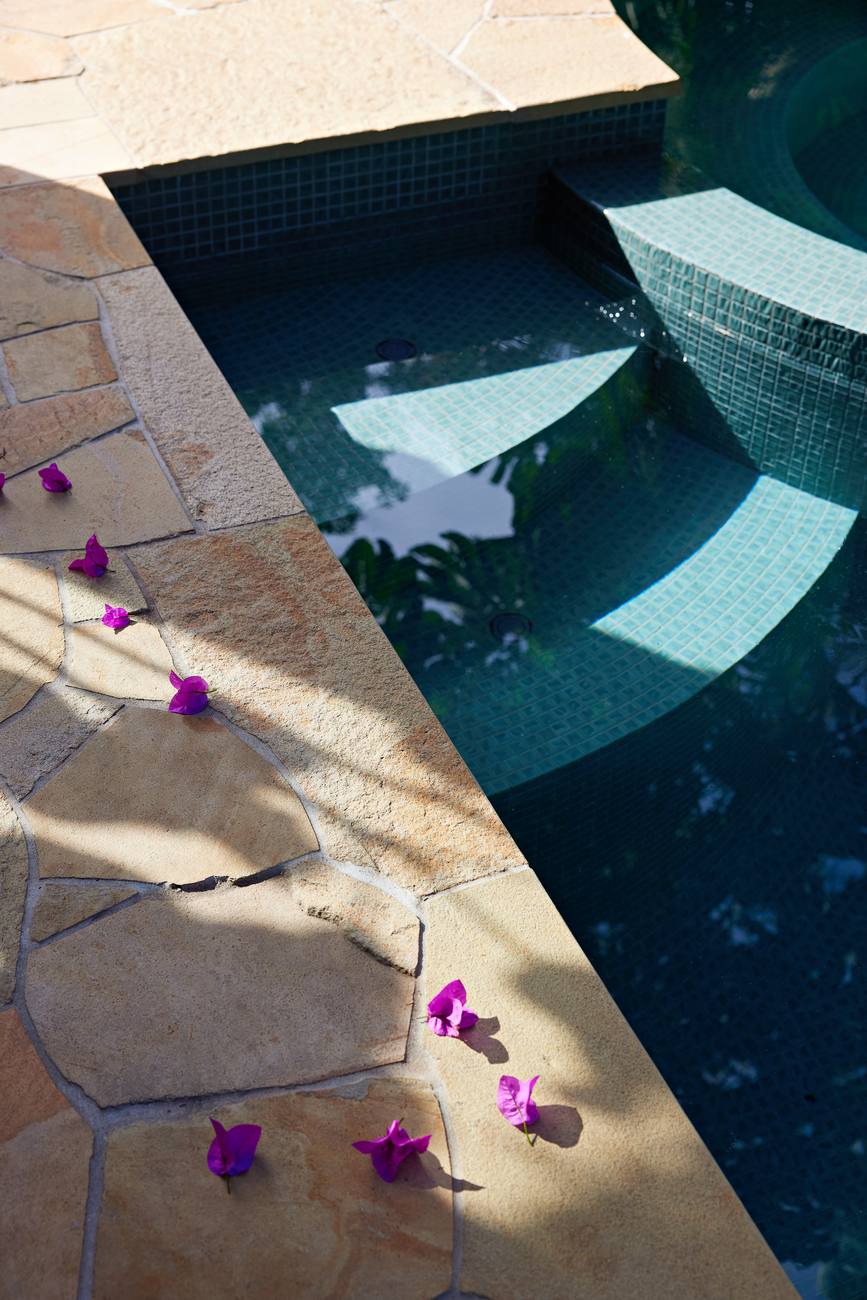 Sandstone coping meeting the green mosaic tile of the pool and spa