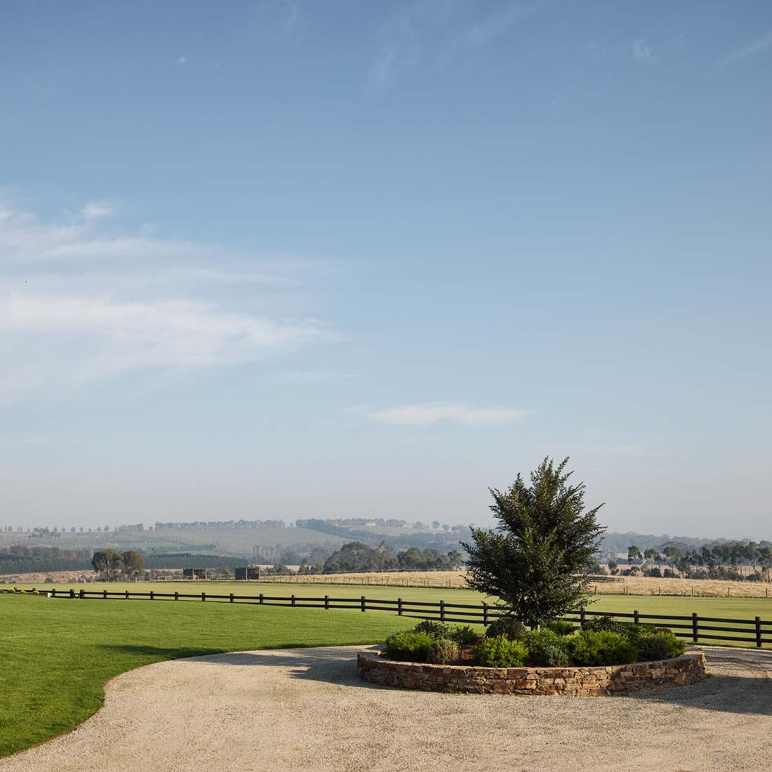 The turning circle planter seen wide, with paddocks and the valley opening behind it