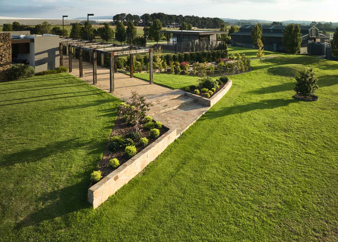 Aerial view of the pergola, flagstone landing and stone retaining wall running out into lawn