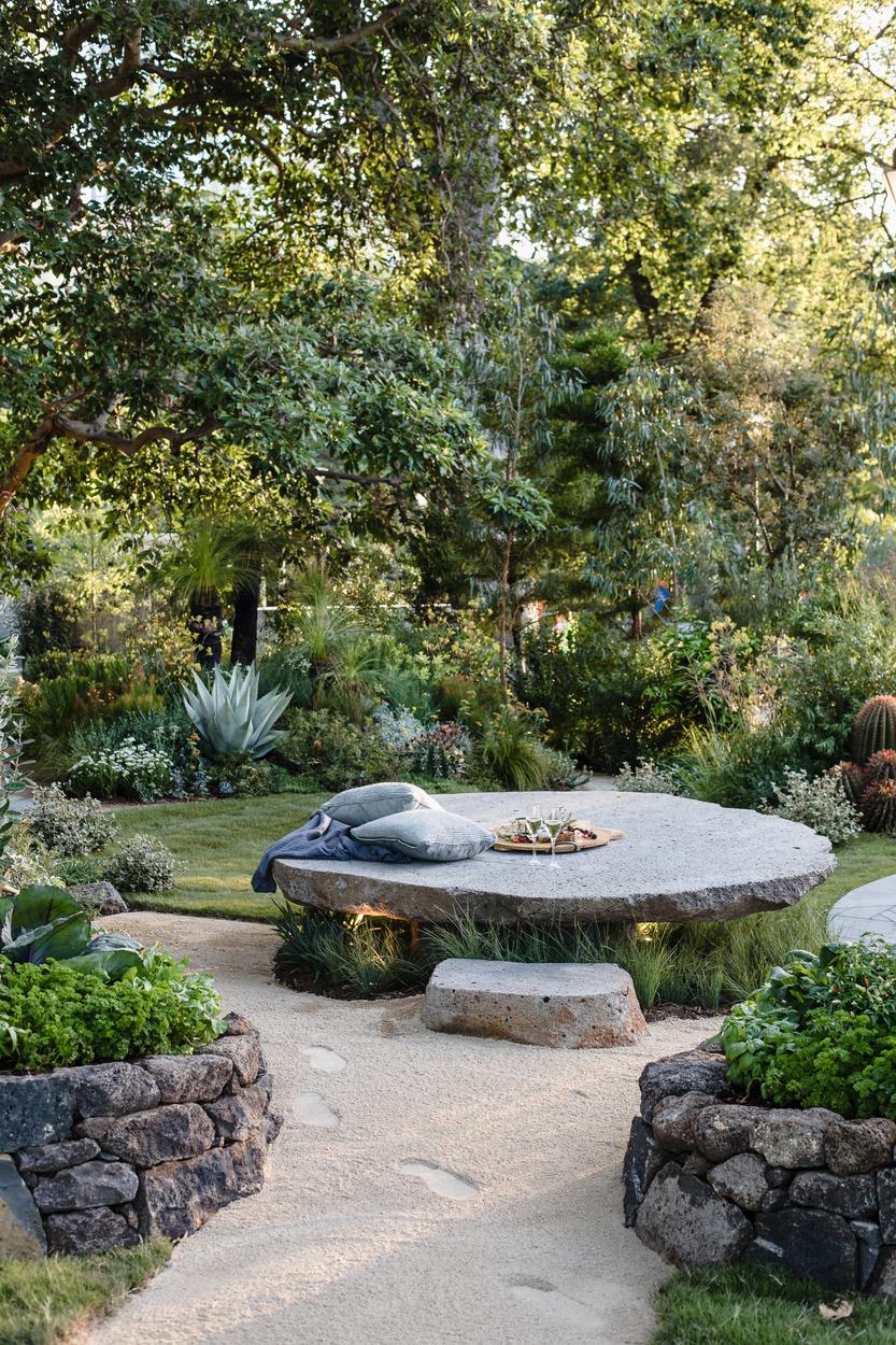 The stone table seen from the herb garden path between dry stone planters