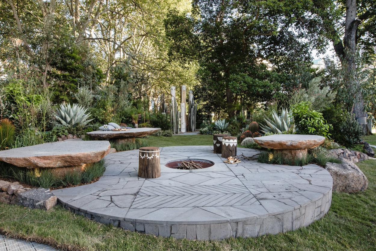 The full fire circle in chevron cut crazy paving, stone tables set around its edge